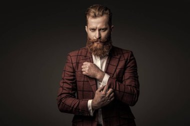 Özel dikim kıyafet giyen bir iş adamı. Şık takım elbiseli bir iş adamı. Resmi terzilik kıyafeti. Erkek giyim kuşamı. Bespoke takımı. Özel dikim erkek giysisi giymiş sakallı adam. İmza biçimi.