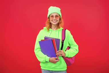 Okula dönelim. Bilgi toplama günü. Üniversitede eğitim. Pembe üzerine izole edilmiş bir kızın ödevi. Bilgi ve eğitim. Okul eğitimi. Modern eğitim. Kız öğrenci çalışma kitabını tutuyor. Bilgi tabanı.