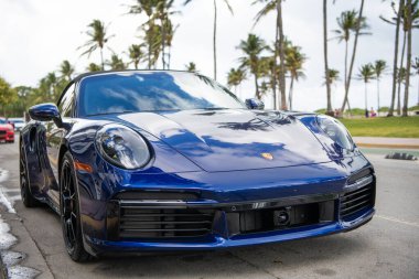 Miami, Florida, ABD - 15 Aralık 2024: Mavi Porsche 992 üstü açık spor araba. Üstü açık Porsche 992 model lüks spor araba. Porsche 992 'nin arabası dışarıda park edilmiş. Porsche 992, ön manzara..