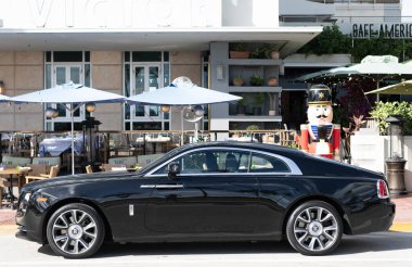 Miami, Florida, ABD - 09 Aralık 2024: siyah 2018 Rolls Royce Wraith arabası. Rolls Royce Wraith 'in lüks arabası. Rolls Royce Wraith 'in arabası dışarıda park edilmiş. Rolls Royce Wraith, yan görünüm.