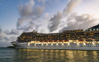 Gemi seyahati. Yaz tatilindeki deniz yolculuğunun havadan görünüşü. Gemi turu ve deniz seyahati. Gece vakti ışıltılı lüks yolcu gemisi yolculuğunun havadan görünüşü. Gemi Miami sahil limanından ayrılıyor. Manzaralı gezi.