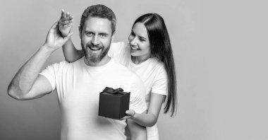 Sevgililer Günü çifti. Birbirine aşık bir çift. Erkek günü hediyesi. Sevgi dolu bir kadın sevgililer gününde hediye veriyor. Sürpriz adama hediye kutusu. Sevgilisinden hediye alan bir erkek arkadaş. Boşluk afişini kopyala.