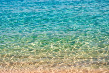 Dalgalı yüzey. Okyanus sahili. Deniz suyu yüzeyi. Okyanusun dalgalı suyu. Aquamarine okyanus doğası. Temiz turkuaz deniz suyunun arka planı. Idyllic yaz tatili. Karayip Denizi. Yazın seyahat..