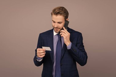 Çevrimiçi bankacılığa telefon. Kredi kartı ya da banka kartı. Telefonda konuşan iş adamı Grey 'de izole edilmiş. İş adamı telefon görüşmesi için kartı kullanır. İş iletişimi devrede. Kartvizit. Benimle temasa geç..