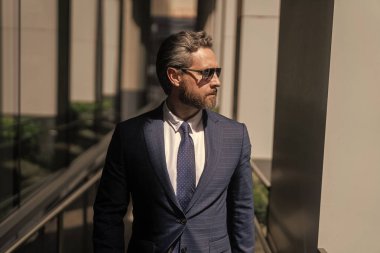 Yakışıklı CEO 'nun portresi. Başarılı bir gelecek vizyonu. Yeni fırsatlar. Ofis binasındaki iş adamı. Başarılı bir iş patronu. İş adamı kıyafeti. Modern cam ofisindeki iş adamı. Çalışma günü.