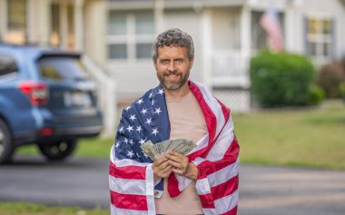 Katma değer vergisi. Vergi sistemi. Vatansever adam. Amerikan bayrağı ve dolar parası olan adam. Enflasyon konsepti. Amerikan vergi politikası. İspanyol adam ve Amerikan bayrağı. Amerika 'da vergi ödemek. Yatırım geliri.