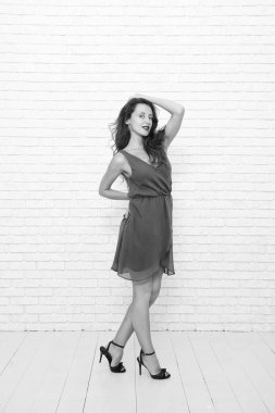Moda elbisesi içinde genç ve güzel bir kadın. Beyaz tenli kadın, beyazın üzerinde yalnız poz veriyor. Mankenler elbise giyer. Zarif ve zarif bir kadın. Şık, sıradan tarzda şık bir kız. Mükemmel görünüş.