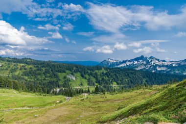 Bulutlu gökyüzü ile dağlık bir manzara. Yeşil Tepe Dağı manzaralı. Yeşil yamaçlı vahşi dağda nefes kesici bir yaz günü. Çayırlı dağ manzarası. Seyahat hedefi.