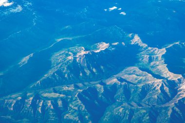 Uçaktan dağa. Dağlı, bulutlu bir manzara. Bulut ve dağ zirvesi hava manzarası. Doğa geçmişi. Dağ manzarasının havadan görünüşü. Hava bulutlu manzara görüntüsü.