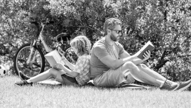 Baba oğul okuma zamanı. Baba oğul açık havada kitap okuyarak kaynaşıyor. Baba ve oğul açık havada kitap okumaya dalmışlardı. Baba ve oğul için özel bir an. okuma maceraları.