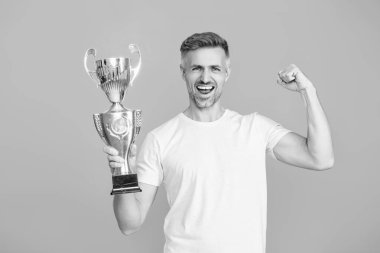 Şampiyon. Spor başarısı ve zafer. Şampiyonluk kupasını tutan adam. Sporda kazanan sporcu. Başarılı bir spor. Olgun bir sporcu gerçek bir şampiyon. Başarıyı kutluyoruz. Güçlü ve mutlu..