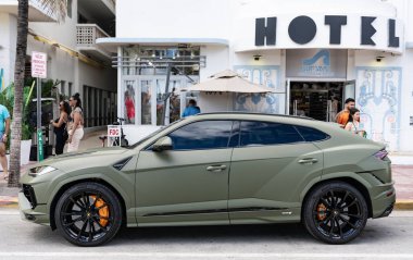 Miami, Florida, ABD - 08 Aralık 2024: Luxur yeşil renkli Lamborghini Urus S tipi spor araba. Lamborghini Urus 'un arabası dışarıda park halinde. Lamborghini Urus, yan görüş. 2024 Lamborghini Urus S SUV arabası.