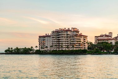 Gün batımında Fisher Adası 'nda. Miami Fisher Adası Panorama Günbatımı Manzarası. Miami plajı, gün doğumu gökyüzü. Miami panorama, Florida. Fisher Adası 'nın panoramik manzarası. Gün doğumu manzarası. Lüks daire..