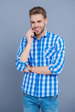 Grey 'de izole edilmiş bir adam telefonda konuşuyor. Millennial Man 'e telefon var. Cep telefonuyla konuşan bir adam. Telefon var. Mobil bağlantı. Kulaklıklı adam. Öğrenci yaşam tarzı. Modern iletişim. Gelen çağrı.