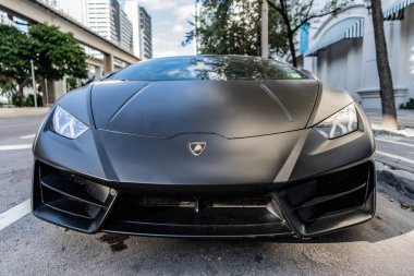 Miami, Florida, ABD - 01 Aralık 2024 Lamborghini Huracan spor araba. Lamborghini Huracan EVO 'nun siyah liman aracı. Lamborghini Huracan 'ın siyah arabası sokakta, ön manzara.