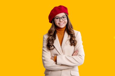 Moda ve şık bir genç kız. Gençler için sonbahar moda tarzı. Sonbahar tarzının modaya uygun portresi. Sonbahar montlu kız sarıda soyutlanmış. Genç kız ceket giyiyor. Sonbahar moda kızı. İkonik dolap parçaları.