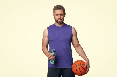 Spor şişeli basketbolcu. Sağlıklı bir yaşam tarzı. Vücutta su dengesi. Sporcu adam su içiyor. Sıvı yeterliliği. Susuz kalma. Susamış sporcu. Susamış adam su içiyor. Eylem planı.