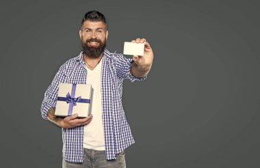 Olgun sakallı, hediye kutusu ve kartı olan bir adam. seçici odak.