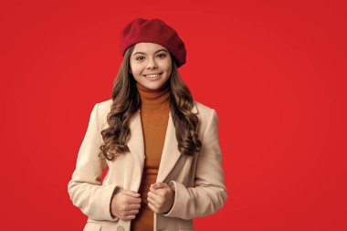 Moda ve şık bir genç kız. Bereli sonbahar kızı. Sonbahar sezonu. Kız sonbaharda şık görünüyor. Gençlik modelinin sonbahar havası. Kırmızıda izole edilmiş sonbahar moda kızı. Sonbahar aksesuarları.