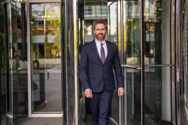 Takım elbiseli adam ofise yürür. Ofis binasındaki İspanyol işadamı. Dışarıda başarılı bir iş adamı. Şehir caddesinde yürüyen bir adam. Takım elbiseli bir iş adamı. İş adamının iş başarısı. Buluşma ortağı.