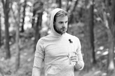 Adam maden suyu tutuyor. Susadım. Plastik şişeli genç bir adam. Sağlıklı bir yaşam tarzı. Vücutta su dengesi. Günde bir içki. Sıvı kaybı ve denge. Susuz kalma. Susamış sporcu..