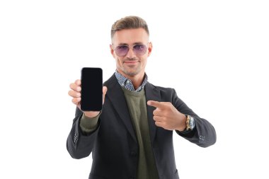 İş adamı, telefonun beyazda izole olduğunu gösteriyor. Adam yeni iş telefonu uygulamasını gösteriyor. Ürünü sunuyorum. İşaret parmağı. İş uygulamasının reklamı. Olgun iş adamı telefon ekranı sunar.