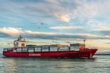 Miami, Florida, ABD - 3 Ocak 2025: Gündoğumunda konteyner gemisi. Kargo gemisi Seaboard Genesis ve konteynır Miami 'de. Yük konteynırı kargo gemisine yüklendi. Hava görüntülü kargo gemisi limana giriyor..