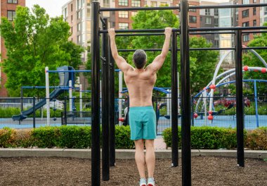 Kas kasları ve trisepsler. Güçlü bir atlet. Adam yanaşıyor. Güçlü sırt kası olan kaslı bir sporcu. Spor barfiks egzersizi. Spor eğitimi. Sporcu adam egzersiz yapıyor. Rutini göster.