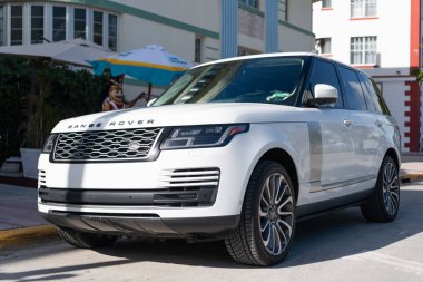 Miami, Florida, ABD - 17 Aralık 2024: Land Rover Range 2018 geçiş aracı. Land Rover 'ın lüks aracı. Beyaz araba Range Rover 'ı dışarıda park etmiş, köşe manzaralı.