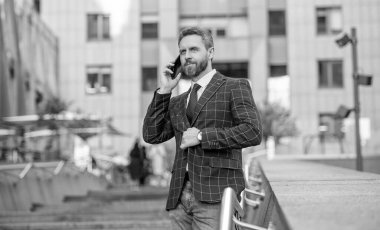 İş adamı ön ofiste. Sosyal ağ. Ofis binasında telefonu olan İspanyol bir iş adamı. Telefon kullanan bir iş adamı. Şehirdeki erkek telefon konuşmaları. İş adamı telefonda konuşuyor. İletişim.