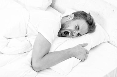 Sabahın köründe esnemek. Uyuyan genç adam uyuyor. Rahat bir yatakta huzur içinde dinleniyor. Kapalı gözlerle yalan söylemek. Geceleri uyuyan bir adam. Uykulu adam beyaz yatak odasında uyuyor..