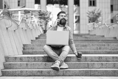 Telefondaki serbest iletişim konuşmalarıyla neşeli bir adam. Dizüstü bilgisayarında serbest iletişimi olan bir adam. Dışarıda serbest çalışan bir adam var. Serbest iletişimi olan bir adam..