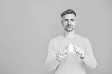 Burun spreyi sunan bir adam. Burun sulama. Burun akıntısı tedavisi. Rhinitis. İlaç ve sağlık hizmetleri. Tıbbi sprey ya da damla. Burun ya da göz tedavisi gören bir adam. Boşluğu kopyala.