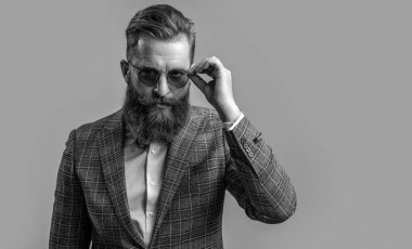 Smokinli, sakallı, şık erkek giyimli, takım elbiseli ve papyonlu bir adam. Gri, fotokopi alanında izole edilmiş..