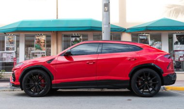 Miami, Florida, ABD - 15 Aralık 2024: kırmızı Lamborghini Urus 2022 çapraz otomobil. Lamborghini Urus tipi lüks bir arazi aracı. Lamborghini Urus 'un arabası dışarıda park edilmiş. Lamborghini Urus, yan görüş