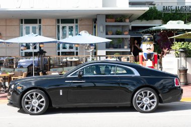 Miami, Florida, ABD - 09 Aralık 2024: siyah 2018 Rolls Royce Wraith arabası. Rolls Royce Wraith 'in lüks arabası. Rolls Royce Wraith 'in arabası dışarıda park edilmiş. Rolls Royce Wraith, yan görünüm.