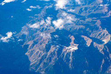 Bulut ve dağ zirvesi hava manzarası. Dağ manzarasının havadan görünüşü. Hava bulutlu görünüyor. Uçaktan manzara. Dağların tepesinde, bulutların içinde. Dağ manzaralı güzel bulutlu doğa.