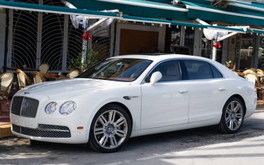 Miami, Florida, ABD - 17 Aralık 2024: 2016 Bentley Flying Spur Vur Sedan Car. Lüks araba beyaz Bentley Flying Spur V8 tipi. Bentley Uçan Mahmuz 'un arabası dışarıda park edilmiş. Bentley Uçan Mahmuz, yan görünüm.