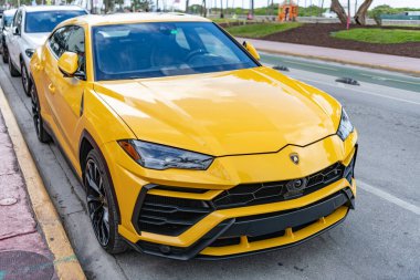 Miami, Florida, ABD - 15 Aralık 2024: Sarı Lamborghini Urus 2019 SUV arabası. Lamborghini Urus tipi lüks bir araba. Lamborghini Urus 'un arabası dışarıda park edilmiş. Lamborghini Urus, köşe manzaralı..