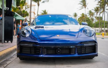Miami, Florida, ABD - 15 Aralık 2024: Mavi Porsche 992 üstü açık spor araba. Üstü açık Porsche 992 model lüks spor araba. Porsche 992 'nin arabası dışarıda park edilmiş. Porsche 992, ön manzara..
