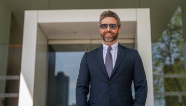 Zarif iş adamı. İş adamı portresi. Başarılı bir iş. Girişimcinin başarısı. Ofis müdürü. Takım elbiseli bir iş adamı. İş adamı ofisten ayrılıyor. Boşluğu kopyala.