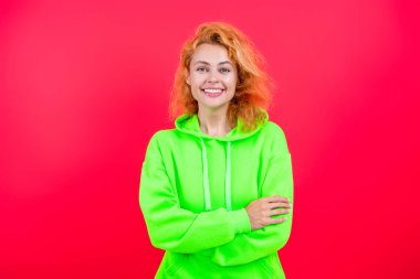 Pembe kapüşonlu bir kadın. Moda modeli. Şık kapüşonlu kızıl saçlı kız. Sıradan kapüşonlu, şık, beyaz bir kadın. Modayla ilgilenen kız modaya uygun ve parlak görünüyor. Çabasız cazibe.