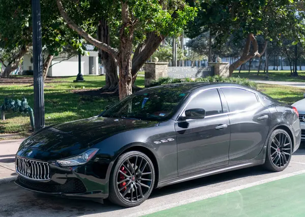 Miami, Florida, ABD - 17 Aralık 2024: Black 2014 Maserati Ghibli spor yara izi. Maserati Ghibli 'nin lüks spor arabası. Maserati Ghibli 'nin arabası dışarıda park edilmiş. Siyah Maserati Ghibli, köşe görünümü.