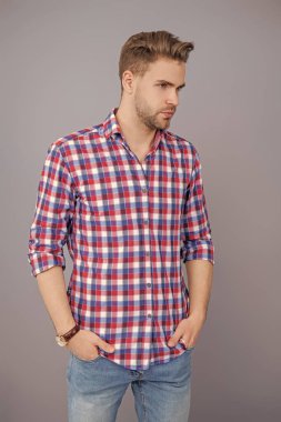 Saç stili olan yakışıklı bir genç. Moda erkek modası. Normal erkek stili. Cilt bakımı ve erkeklerin güzellik anlayışı. Kafkasyalı milenyum adamı. Gri tişörtlü adam izole edilmiş. Erkek cazibesi.