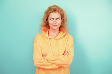 Sıradan kapüşonlu, şık, beyaz bir kadın. Modayla ilgilenen kız modaya uygun ve parlak görünüyor. Mavi üzerine kapüşonlu giyen kadın. Moda modeli. Şık kapüşonlu kızıl saçlı kız. Kapüşonlu kazak.