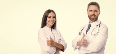 Tıbbi servis ilanı. Tıp hastanesinde iki hemşire ve doktor. Sağlık doktoru beyazı izole etti. İlaç ve sağlık sigortası. Doktor reklam öneriyor, başparmağınızı kaldırın. Boşluğu kopyala.