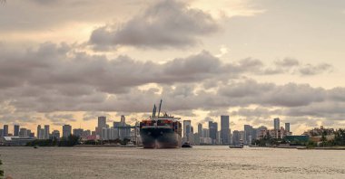 Kargo gemisi limandan ayrılıyor. Kargo işi. Konteyner gemisi. Nakliye lojistiği. Miami ufuk çizgisinde konteynırlı bir kargo gemisi. Konteynır Miami Skyline, Florida 'da kargo gemisine yüklendi..