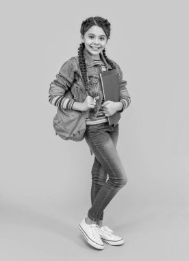 Mutlu liseli kız sarı arka plan, eğitim. Elinde kitap tutan ergen bir kız. Okul eğitimi. Resmi olmayan ve gayri resmi eğitim.