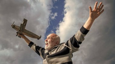 Emekli kıdemli bir adamın mutluluğu. Emekli olmuş olgun bir adam. Gökyüzündeki yaşlı adam oyuncak uçağıyla dışarıda.