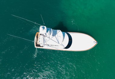 Sürat teknesi denize açılıyor ve denizde balık tutuyor. Motorlu tekne hava görüntüsü. Balıkçı yatı. Denizde lüks bir balıkçı teknesi. Tekne turizmi. Teknede balık tutmak. Lüks bir yaşam tarzı. Yaz tatili. Denizde yat..
